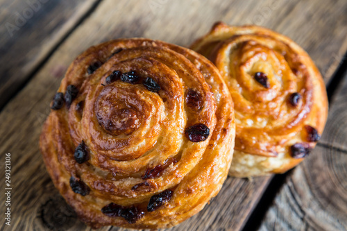 Fresh buns with raisins on a wooden table