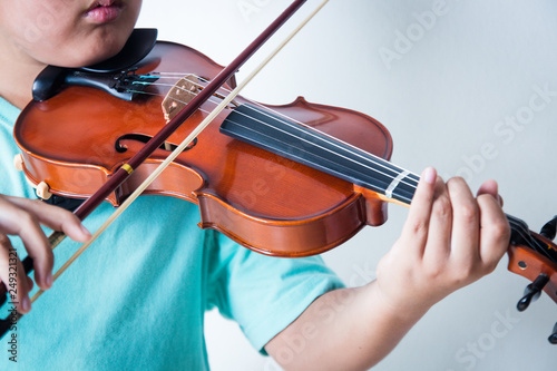 Boy playing violin in room