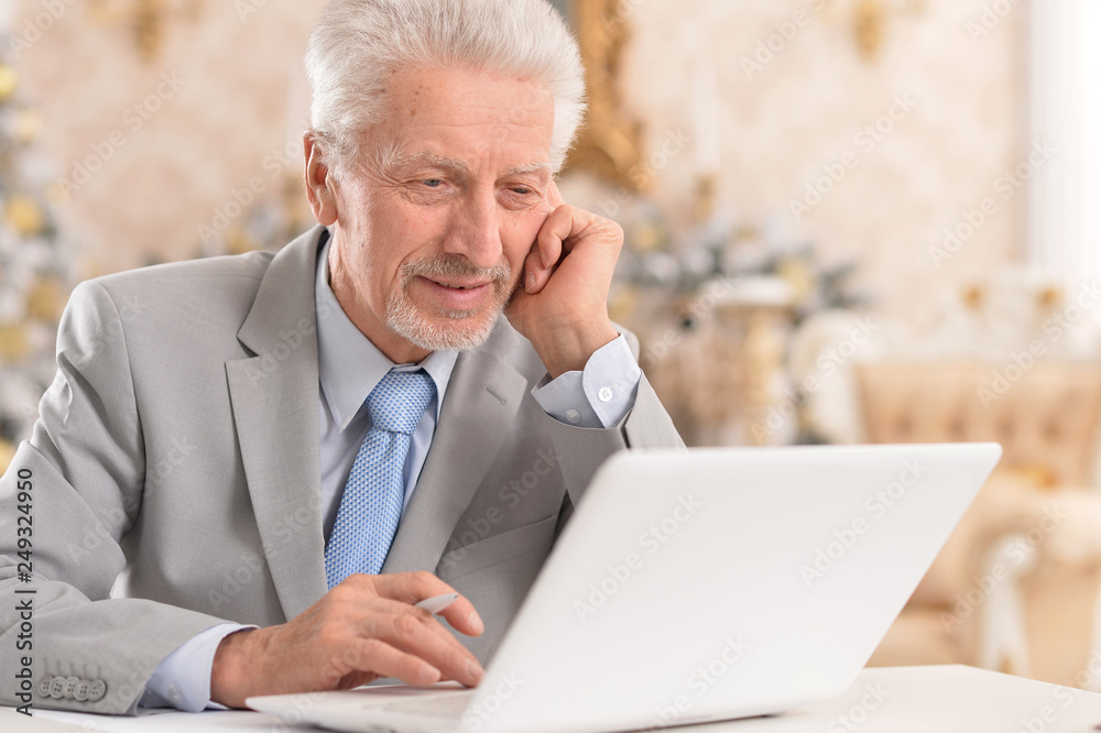 Portrait of happy senior man using laptop at home Portrait of happy senior man using laptop at home