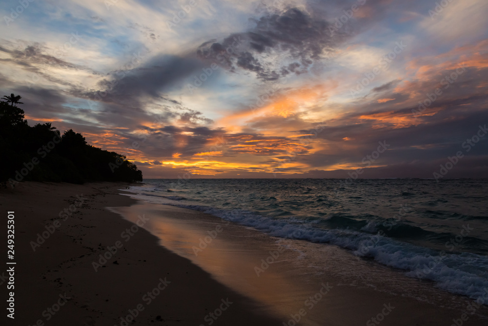 Twilight evening sunset. Waves, surf, swash at empty beautiful sandy beach on Foa island, Haapai islands or Ha'apai group, Tonga, Oceania, South Pacific Ocean. Near Lifuka
