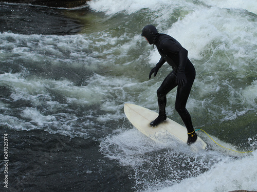 Photography Man in black wetsuit is surfing in waves