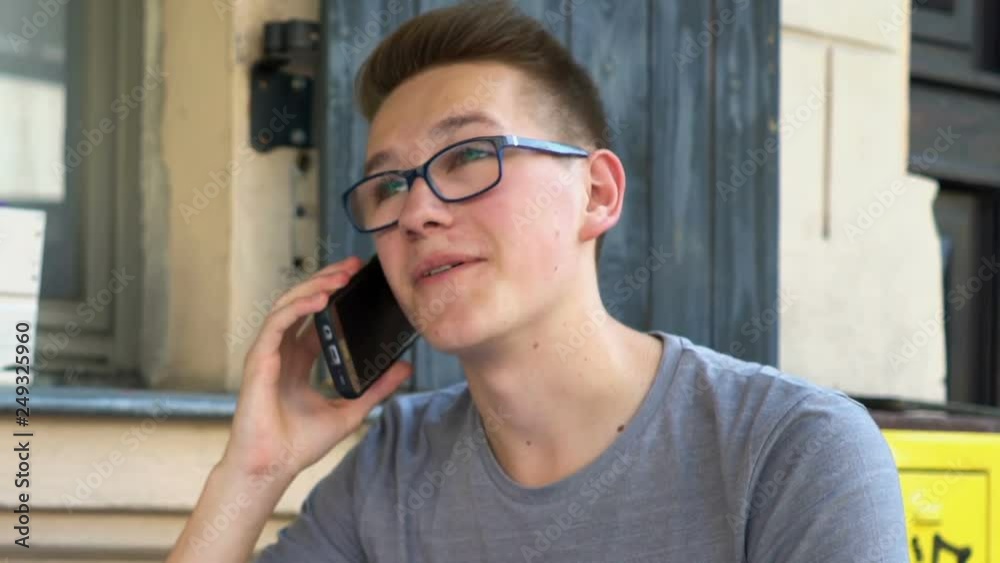 Young happy teenager talking on cellphone in cafe Young happy teenager talking on cellphone in cafe