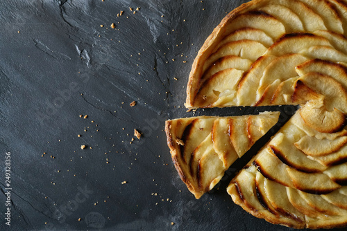 Fotografie Top view of sliced apple tart on slate with text space