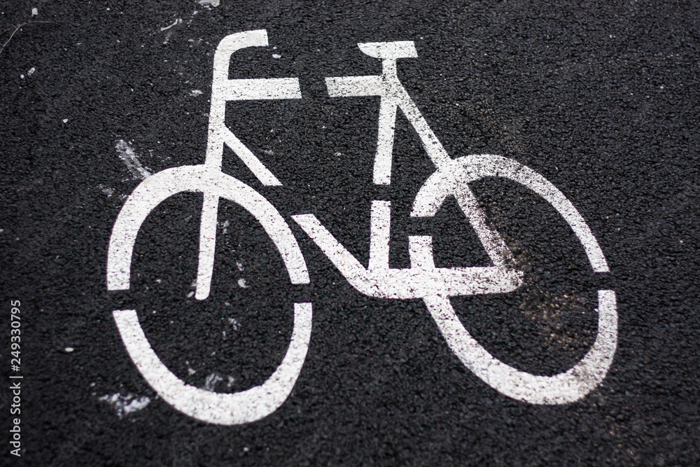 Beautiful view of bicycle sign painted on a black asphalt road. Beautiful view of bicycle sign painted on a black asphalt road.