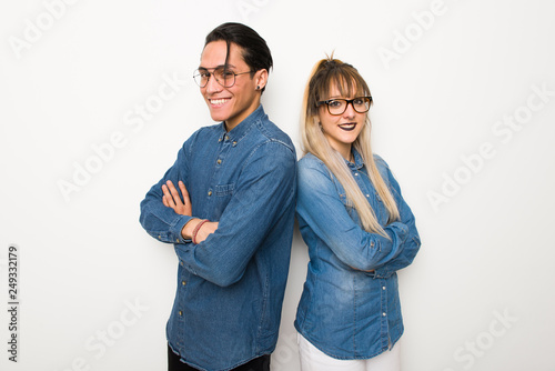 Young couple with glasses keeping the arms crossed in lateral position while smiling