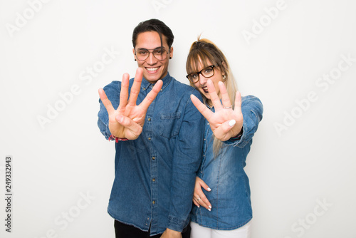Young couple with glasses happy and counting four with fingers