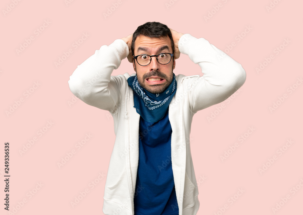 Handsome man with glasses takes hands on head because has migraine on isolated pink background Handsome man with glasses takes hands on head because has migraine on isolated pink background