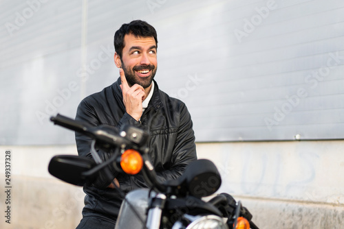 Young man on a motorbike thinking © luismolinero