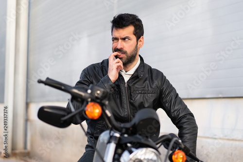 Frustrated young man on a motorbike © luismolinero