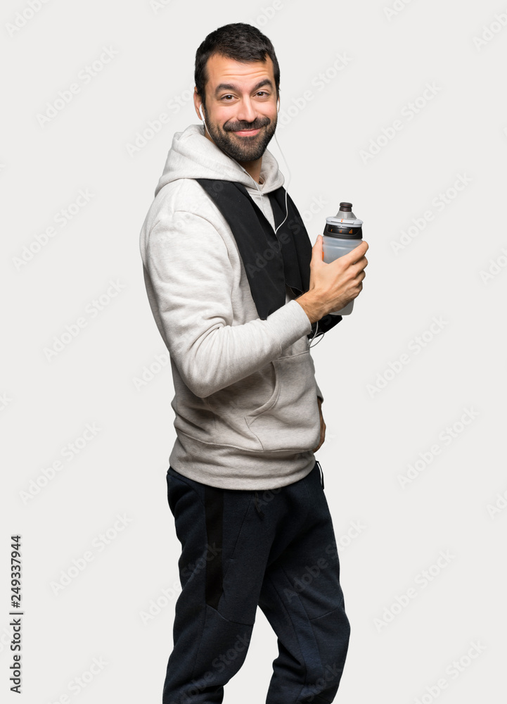 Sport man holding a hot cup of coffee over isolated grey background Sport man holding a hot cup of coffee over isolated grey background