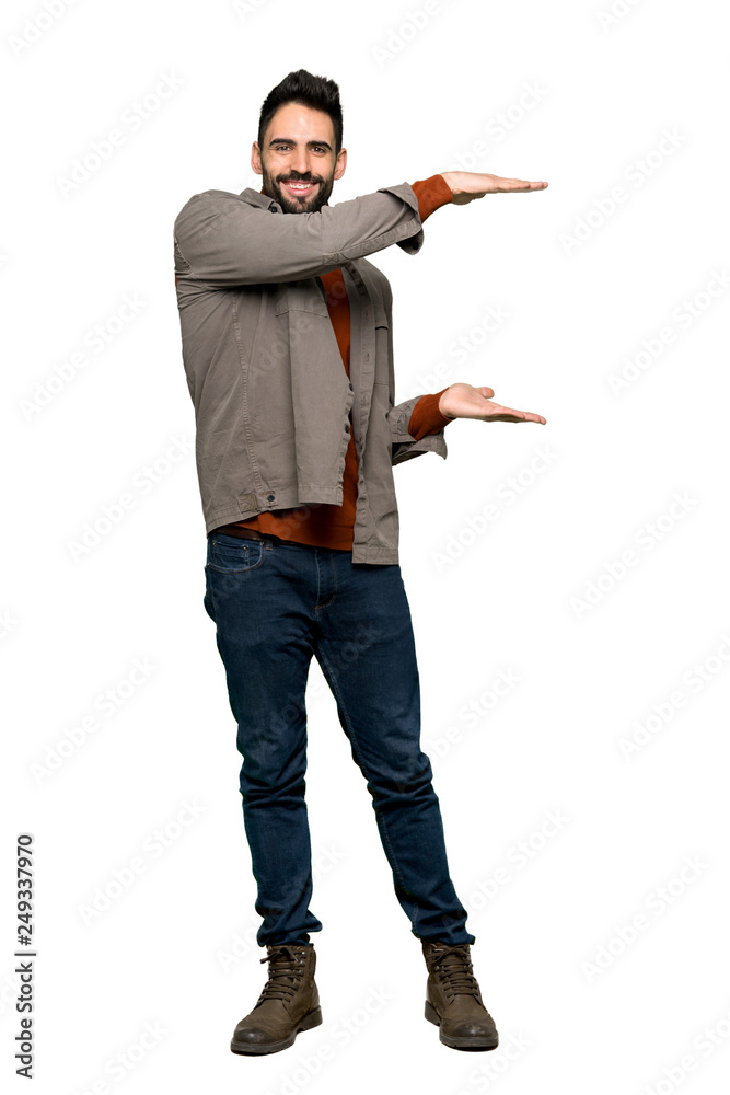 Full-length shot of Handsome man with beard holding copyspace to insert an ad on isolated white background Full-length shot of Handsome man with beard holding copyspace to insert an ad on isolated white background