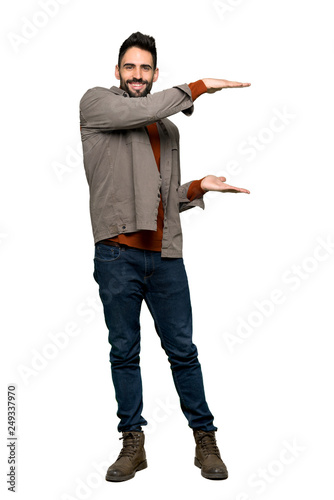 Full-length shot of Handsome man with beard holding copyspace to insert an ad on isolated white background © luismolinero