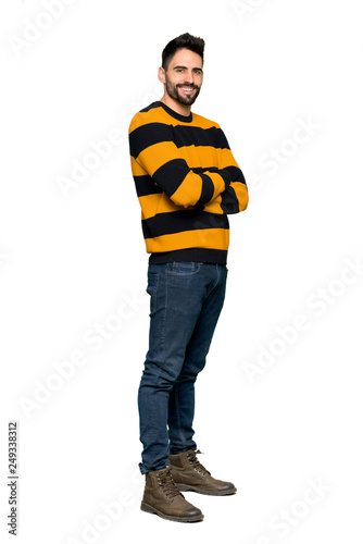 Full-length shot of Handsome man with striped sweater with arms crossed and looking forward on isolated white background