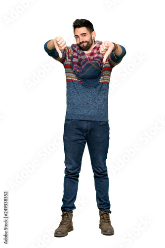 Full-length shot of Hippie man showing thumb down with both hands on isolated white background