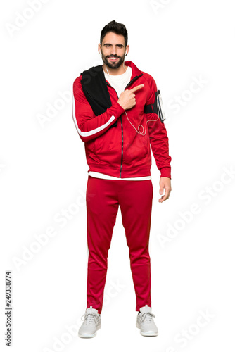 Full-length shot of Handsome sportman pointing to the side to present a product on isolated white background