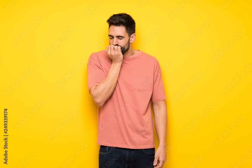 Handsome man over yellow wall having doubts Handsome man over yellow wall having doubts