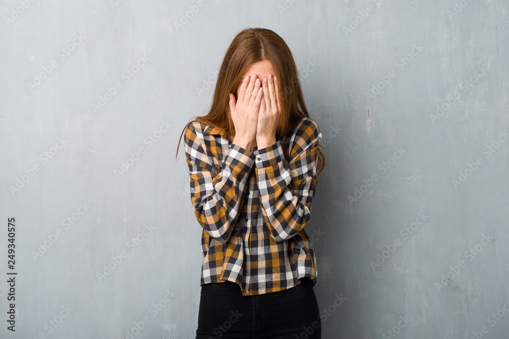 Young redhead girl over grunge wall with tired and sick expression Young redhead girl over grunge wall with tired and sick expression