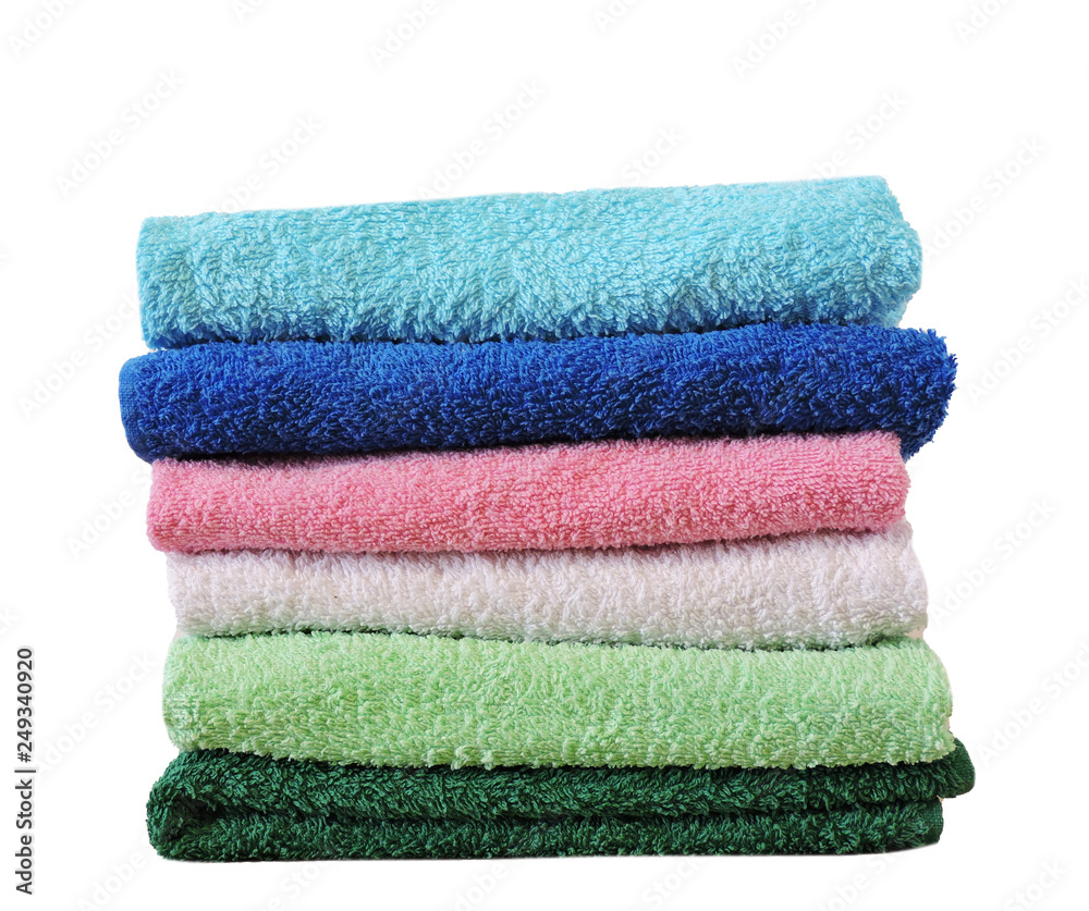 Stack of colorful bath towels on white background.Pile of rainbow colored towels isolated.Top view.Hygiene, fabric,spa and textile concept. Stack of colorful bath towels on white background.Pile of rainbow colored towels isolated.Top view.Hygiene, fabric,spa and textile concept.