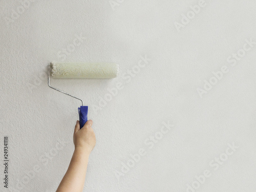 paint roller paints a white wall