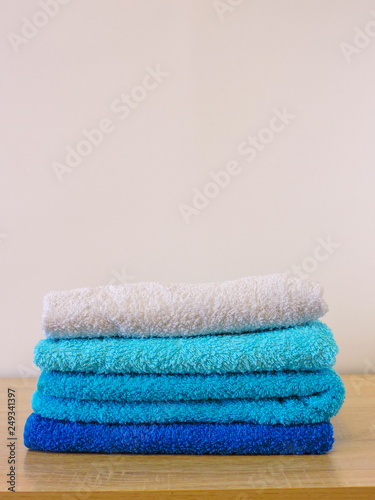Stack of colorful bath towels  on white background.Pile of rainbow colored towels isolated.Top view.Hygiene, fabric,spa and textile concept.