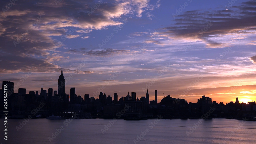 east river and New York City Manhattan midtown silhouette panorama at sunset with skyscrapers