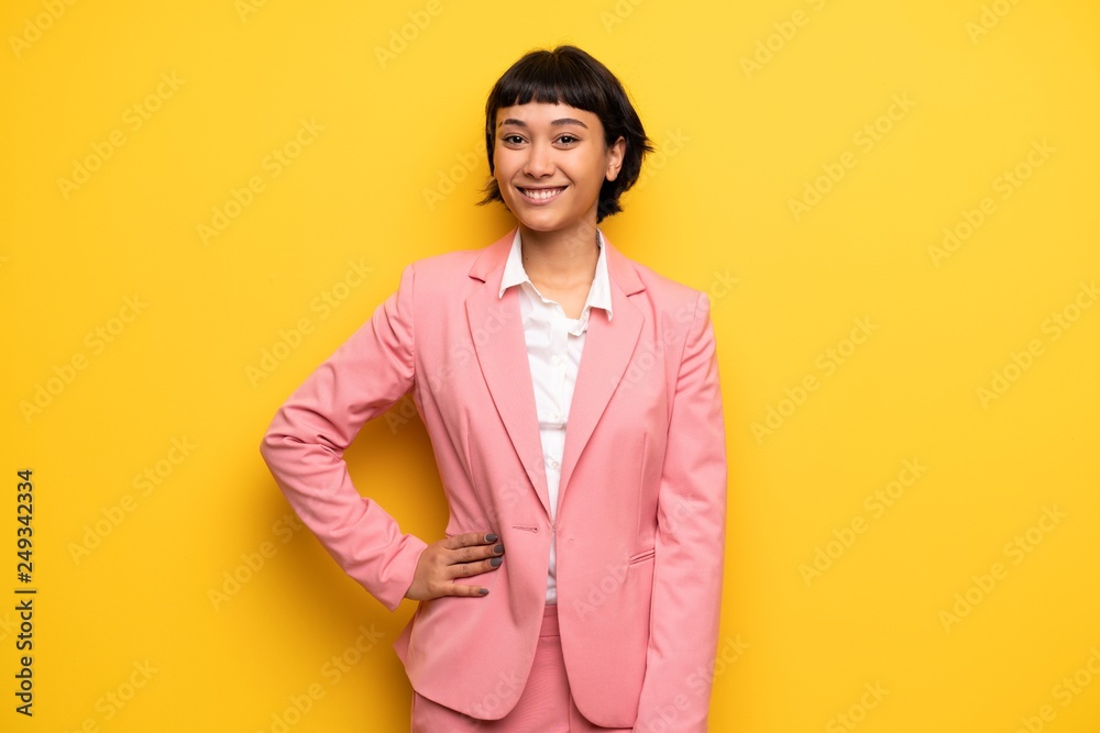 Modern woman with pink business suit posing with arms at hip and smiling Modern woman with pink business suit posing with arms at hip and smiling