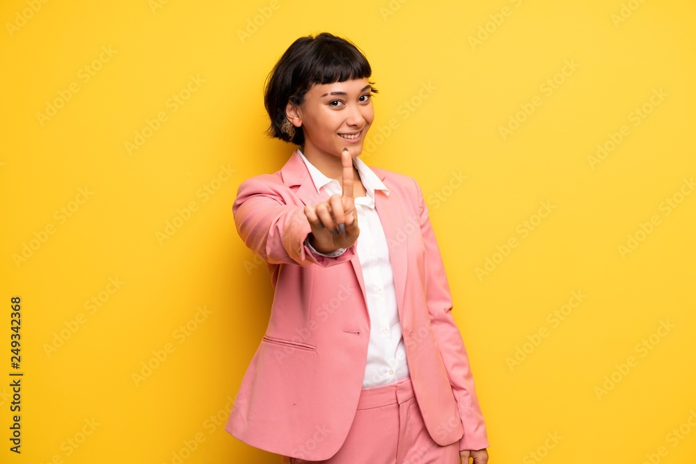Modern woman with pink business suit showing and lifting a finger Modern woman with pink business suit showing and lifting a finger