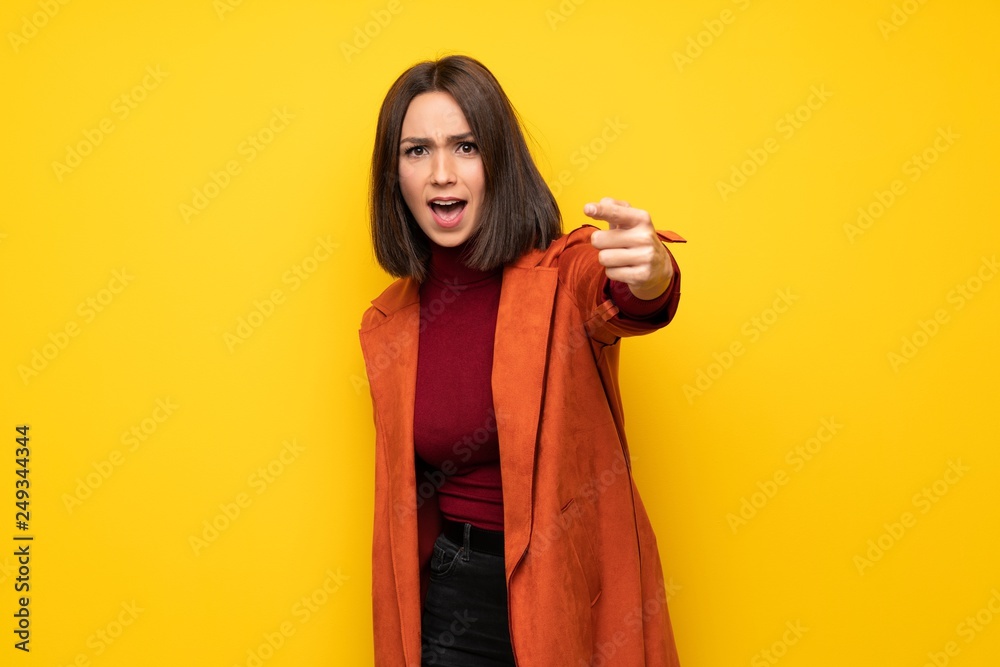 Young woman with coat frustrated and pointing to the front Young woman with coat frustrated and pointing to the front