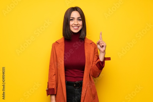 Young woman with coat pointing with the index finger a great idea © luismolinero