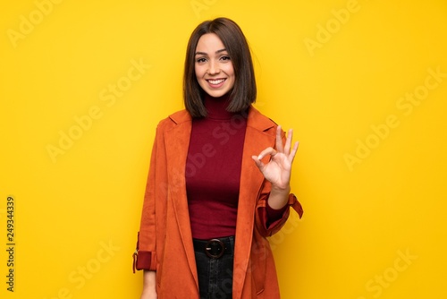 Young woman with coat showing ok sign with fingers © luismolinero