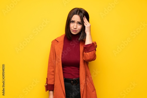 Young woman with coat with headache © luismolinero