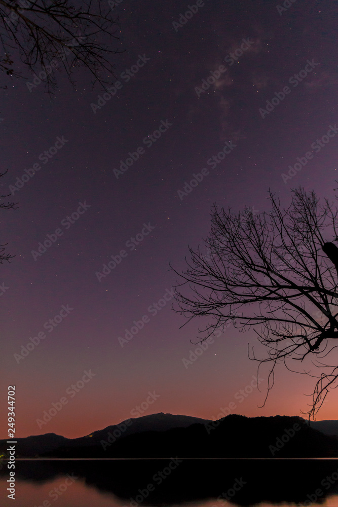 Sunset on a lake with mountains in the background, starry night sky. Sunset on a lake with mountains in the background, starry night sky.