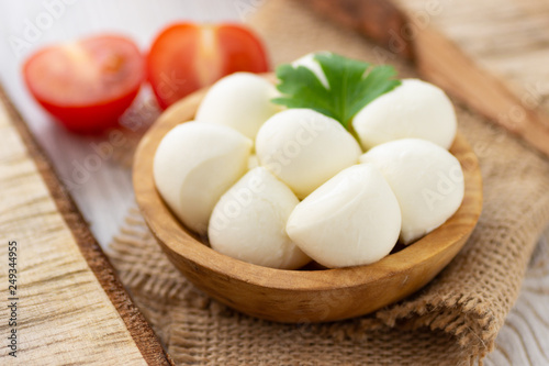 Mozzarella cheese in wooden bowl. Rustic style.