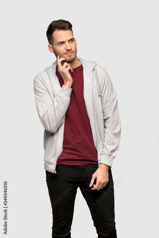 Man with sweatshirt thinking an idea while looking up over grey background Man with sweatshirt thinking an idea while looking up over grey background