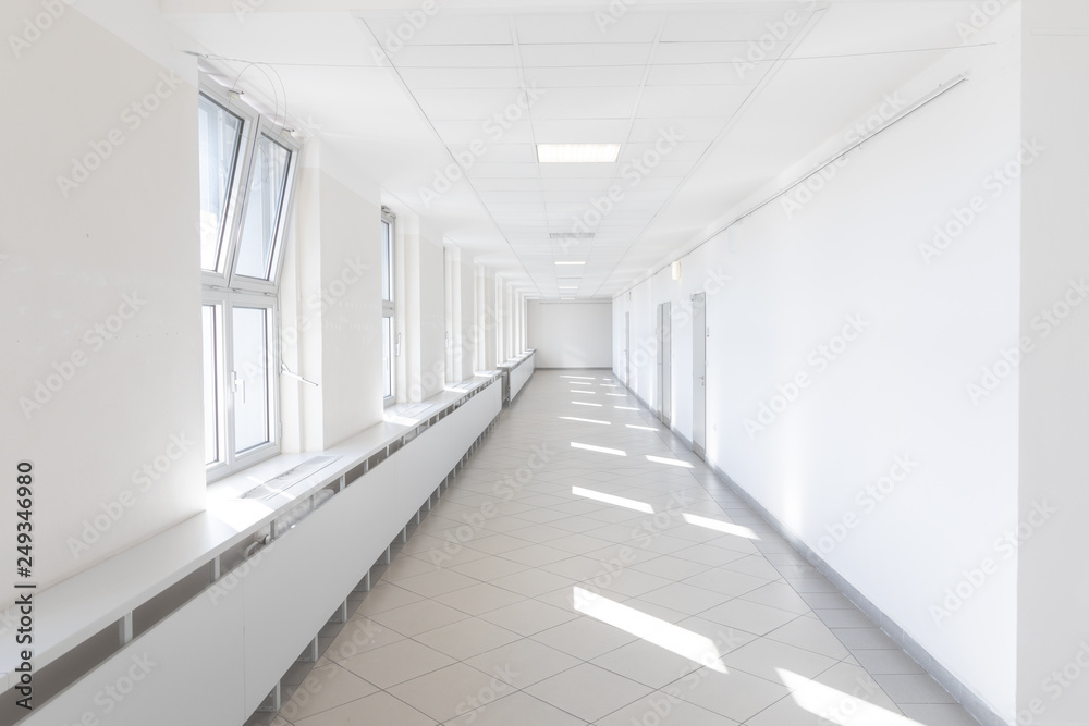 Hospital corridor bright light windows sun rays long white nobody empty
