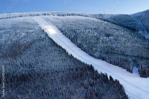 Ski slope resort panorama at evening night with a snowcat working, Stoh - Spindleruv Mlyn, Czechia photo