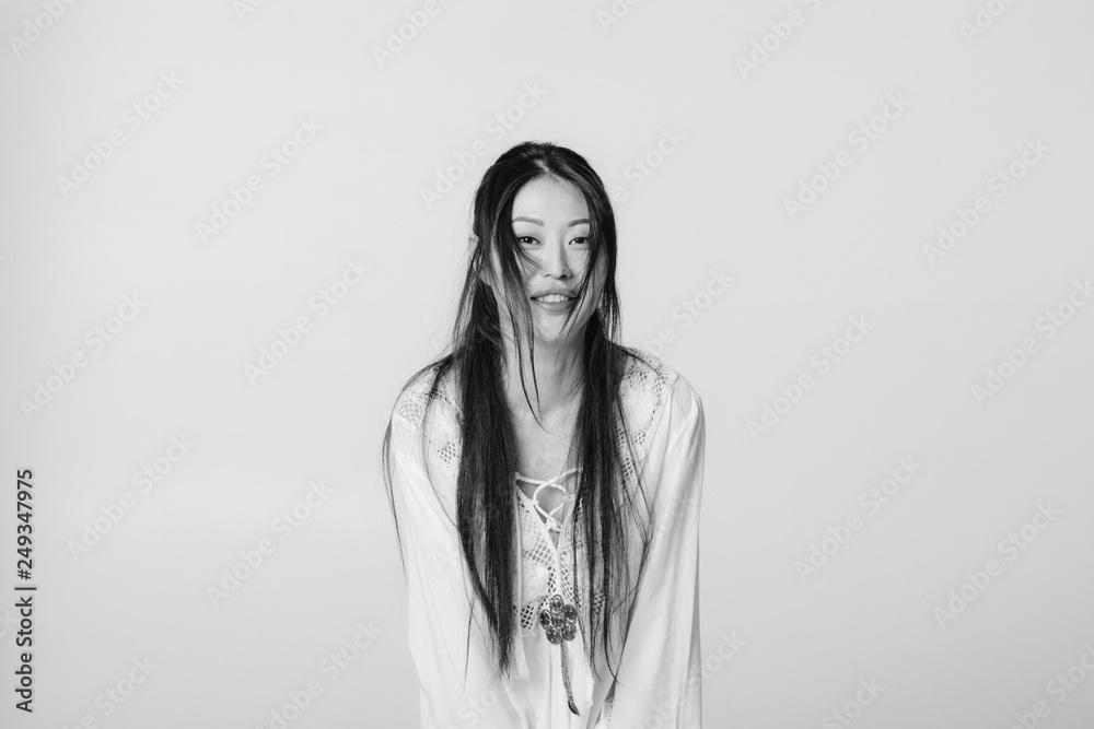 beautiful smiling asian woman in white shirt posing in studio. black and white shot