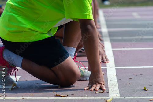 The man athletes sprinting. Men in sport clothes run at the running track in professional stadium.