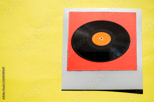 Instant photo on colored yellow background. Polaroid vinyl