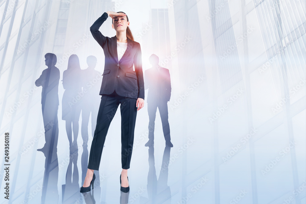 Fototapeta premium Businesswoman looking forward and her team in city