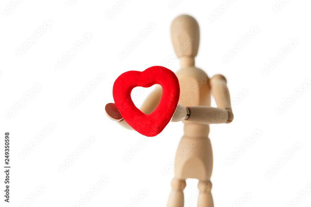 The wooden figure of a man holds in his hands a red heart on a white background. Gives the heart The wooden figure of a man holds in his hands a red heart on a white background. Gives the heart