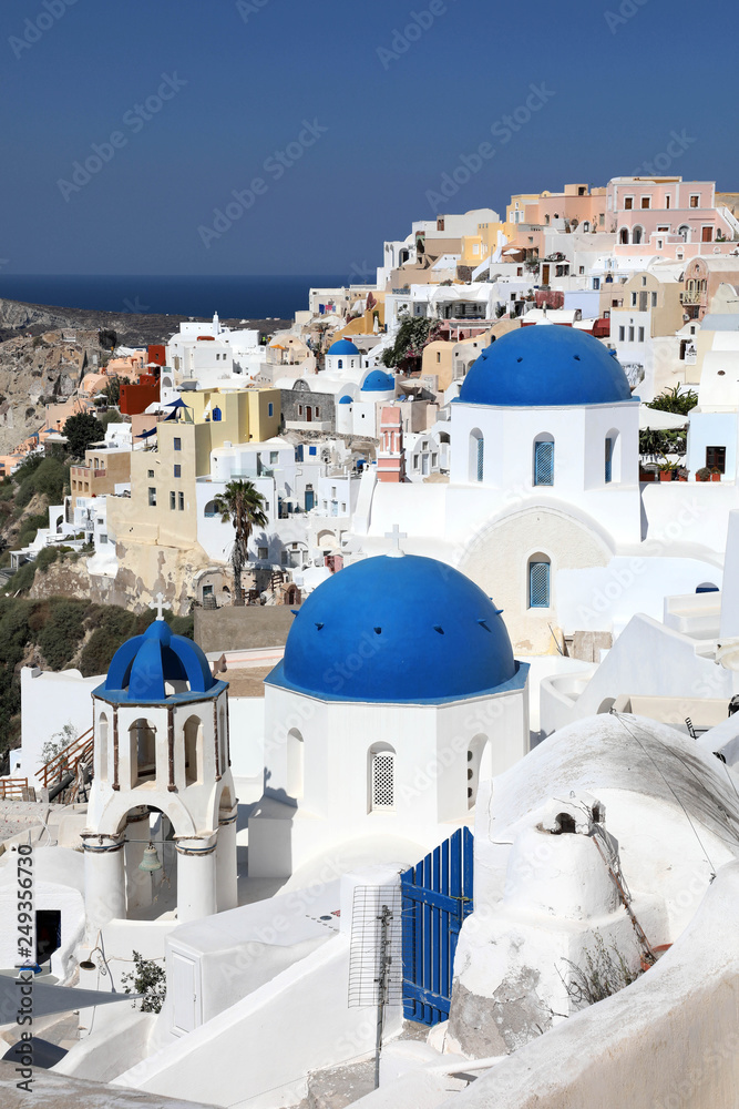 Amazing panorama view with white houses and blue domes in Oia village on Santorini island, Greece