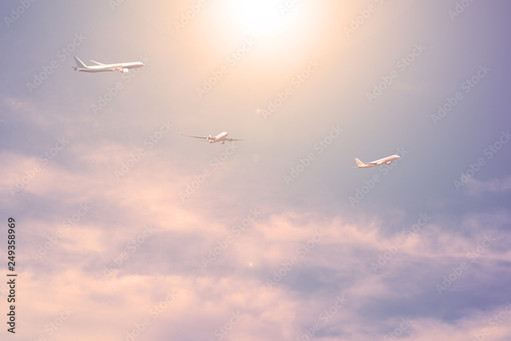 Fototapeta premium Three planes against the blue sky with clouds the sun is shining.