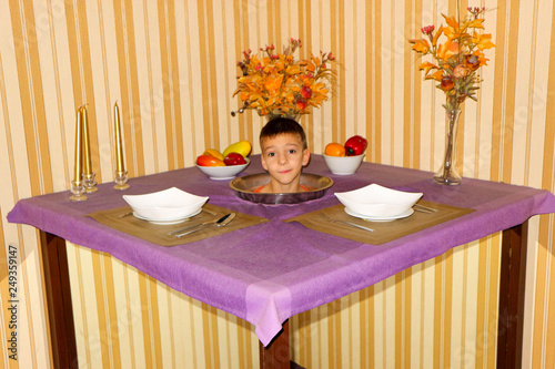 Wallpaper Mural Young boy head on a plate staying on the table in optical illusion Torontodigital.ca