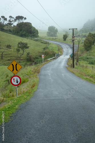 Pohuehue countryside New Zealand. Foggy hills. Road with signs. Bridge photo