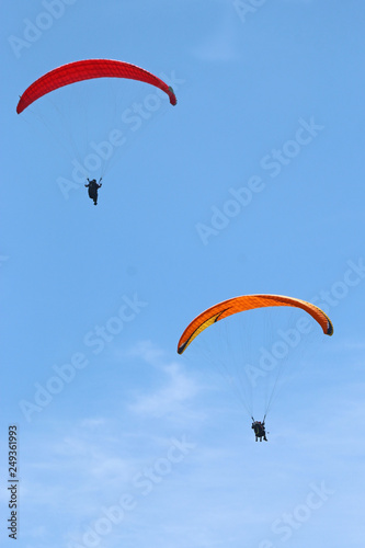 Paragliders flying in a blue sky