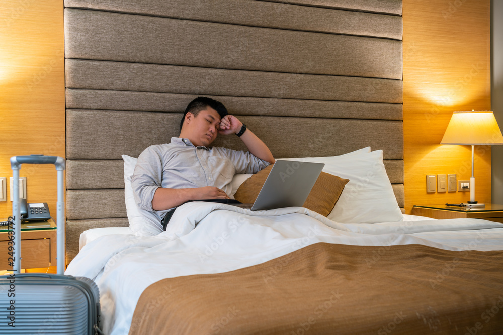 Fototapeta premium Tired Asian businessman working in the hotel room