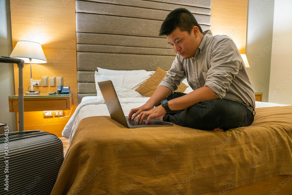 Young Asian businessman working late in the hotel room