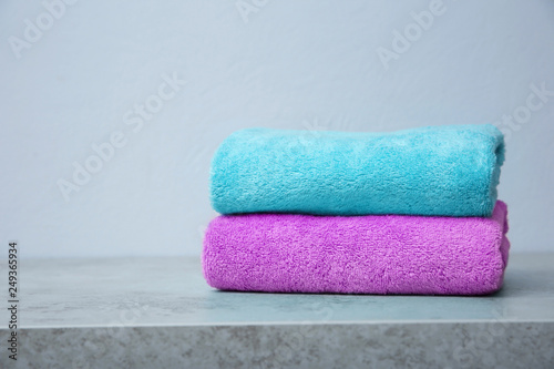 Stack of towels on table against grey background