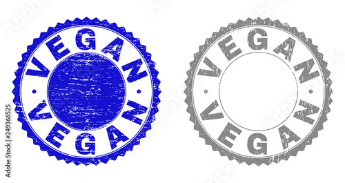 Grunge VEGAN stamp seals isolated on a white background. Rosette seals with distress texture in blue and grey colors. Vector rubber stamp imprint of VEGAN tag inside round rosette.
